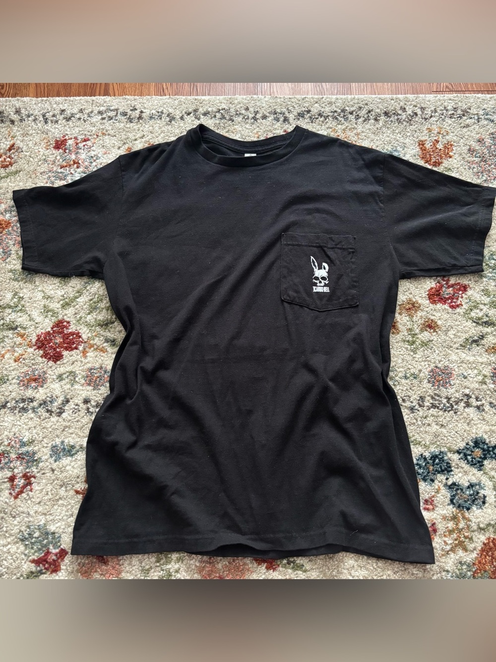 Unisex Black Icarus Bell Tee with White Bunny Skull Graphic on Pocket